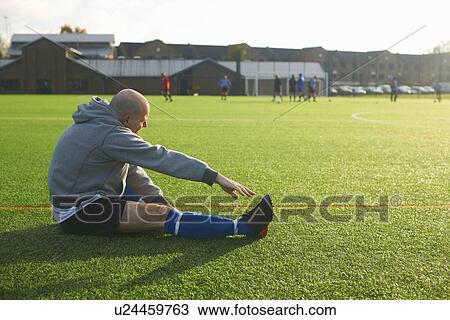 Football player stretching before game View Large Photo Image Stock Image - Football player stretching before game. Fotosearch