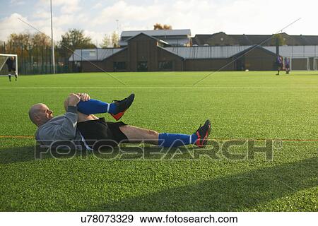 Football player stretching before game View Large Photo Image Stock Photo - Football player stretching before game. Fotosearch