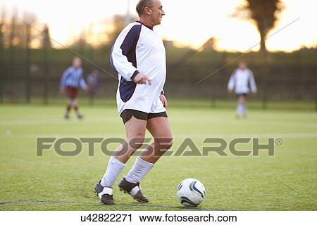 Stock Image - Football player with possession of ball. Fotosearch
