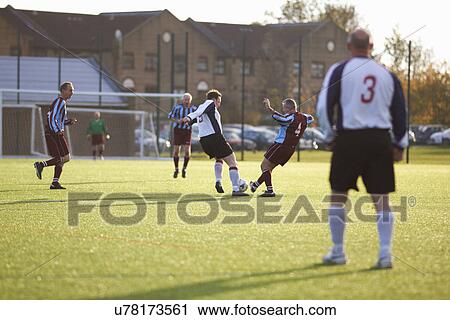 Stock Image - Football players fighting for ball. Fotosearch