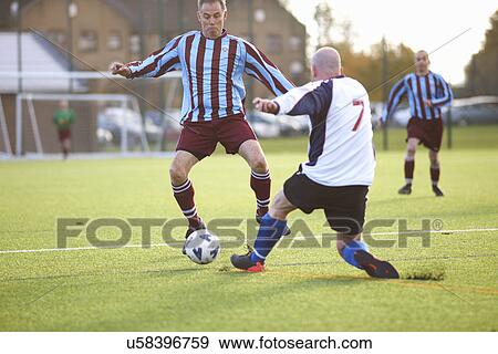 Stock Photo - Football players fighting for ball. Fotosearch