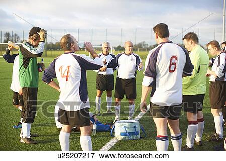 Stock Photo - Football players resting and hydrating at half time. Fotosearch