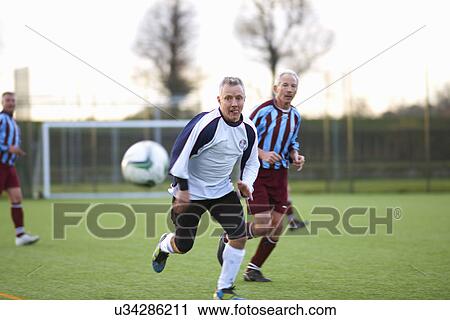 Football players running after ball View Large Photo Image Stock Image - Football players running after ball. Fotosearch