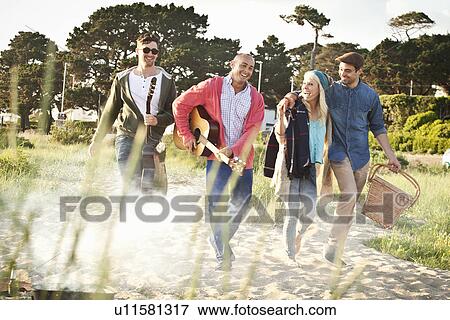Four adult friends with acoustic guitar and picnic basket on Bournemouth beach, Dorset, UK View Large Photo Image Stock Photo - Four adult friends with acoustic guitar and picnic basket on Bournemouth beach, Dorset, UK. Fotosearch