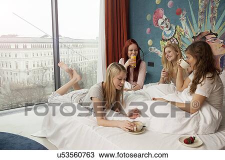 Four young women friends breakfasting on hotel bed View Large Photo Image Stock Image - Four young women friends breakfasting on hotel bed. Fotosearch