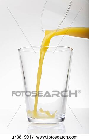 Fresh orange juice pouring from jug into drinking glass View Large Photo Image Stock Photo - Fresh orange juice pouring from jug into drinking glass. Fotosearch