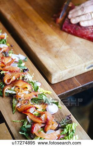 Stock Photography - Gravlax salmon salad on wooden board. Fotosearch