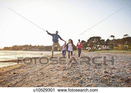 Stock Image - Group of friends having fun on beach. Fotosearch