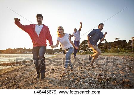 Stock Photo - Group of friends having fun on beach. Fotosearch