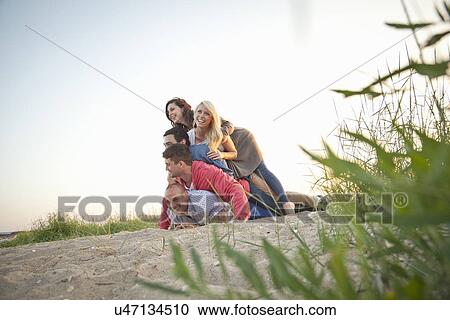 Group of friends making human pile on beach View Large Photo Image Stock Image - Group of friends making human pile on beach. Fotosearch