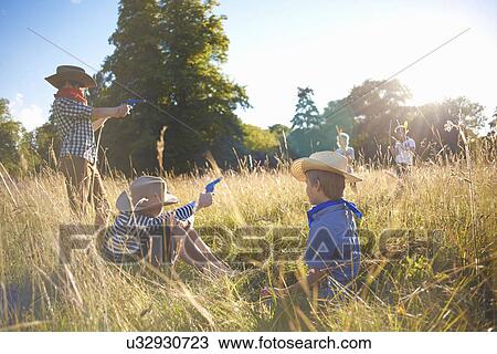 Group of young boys playing in a field View Large Photo Image Stock Image - Group of young boys playing in a field. Fotosearch