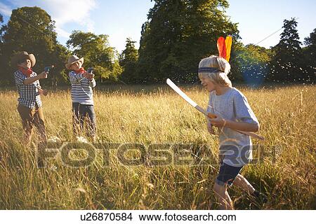 Picture - Group of young boys playing in field. Fotosearch