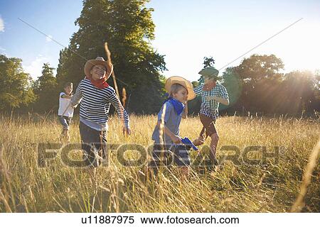 Group of young boys playing in field View Large Photo Image Stock Photography - Group of young boys playing in field. Fotosearch