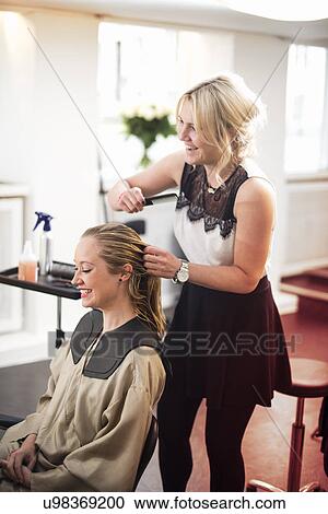 Hairdresser combing customer's hair View Large Photo Image Stock Image - Hairdresser combing customer's hair. Fotosearch