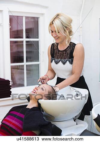 Hairdresser washing customer's hair View Large Photo Image Stock Image - Hairdresser washing customer's hair. Fotosearch