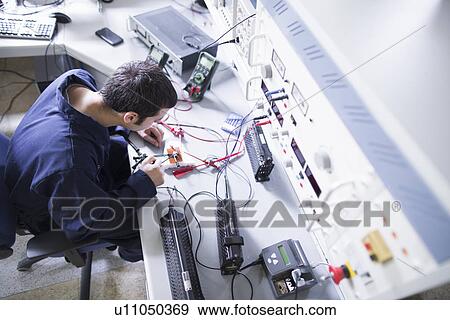High angle view of male electrician repairing electronic equipment in workshop View Large Photo Image Stock Photo - High angle view of male electrician repairing electronic equipment in workshop. Fotosearch