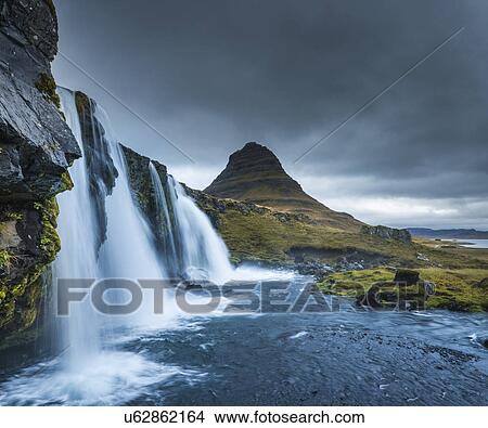 Picture - Kirkjufellsfoss waterfall, Mt. Kikjufell in background, Snaefellsnes, Iceland. Fotosearch
