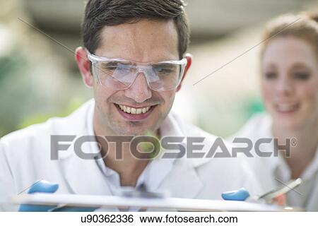 Male and female scientists looking at plant sample View Large Photo Image Stock Photograph - Male and female scientists looking at plant sample. Fotosearch