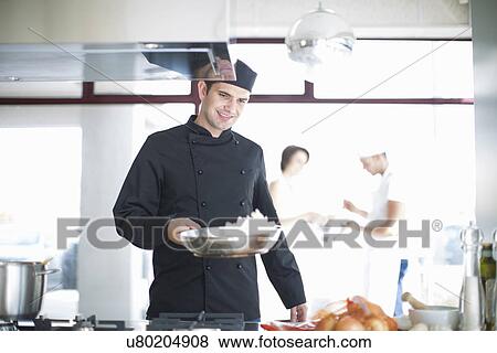 Male chef carrying frying pan in commercial kitchen View Large Photo Image Stock Photo - Male chef carrying frying pan in commercial kitchen. Fotosearch