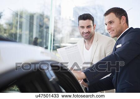 Male customer and salesman chatting in car dealership View Large Photo Image Stock Image - Male customer and salesman chatting in car dealership. Fotosearch