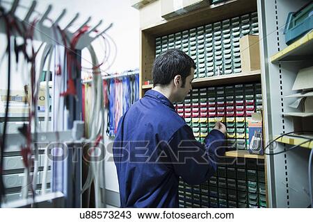 Male electrician selecting equipment from drawers in workshop View Large Photo Image Stock Image - Male electrician selecting equipment from drawers in workshop. Fotosearch
