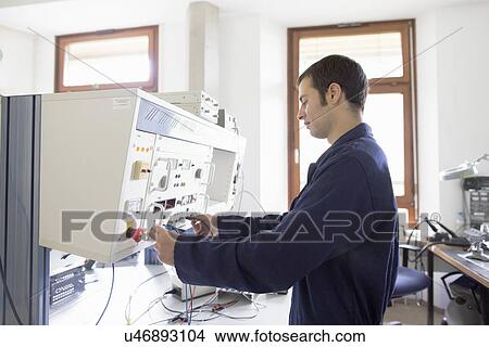 Picture - Male electrician testing control panel workshop. Fotosearch