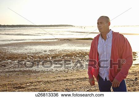 Man looking into distance on beach View Large Photo Image Stock Photograph - Man looking into distance on beach. Fotosearch