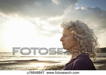 Stock Photo - Mature woman enjoying beach. Fotosearch