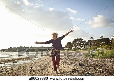 Mature woman enjoying beach View Large Photo Image Stock Photograph - Mature woman enjoying beach. Fotosearch