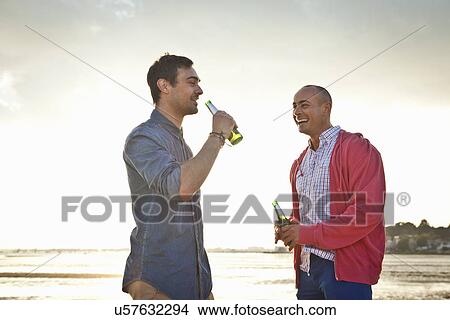 Men drinking beer and chatting on beach View Large Photo Image Picture - Men drinking beer and chatting on beach. Fotosearch