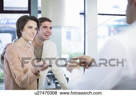 Mid adult couple and salesman looking at ceramic tile in kitchen showroom View Large Photo Image Stock Photo - Mid adult couple and salesman looking at ceramic tile in kitchen showroom. Fotosearch