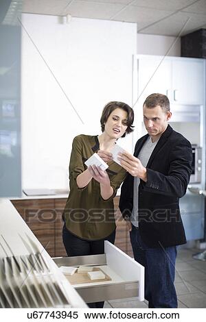 Mid adult couple comparing ceramic tiles in kitchen showroom View Large Photo Image Stock Photography - Mid adult couple comparing ceramic tiles in kitchen showroom. Fotosearch