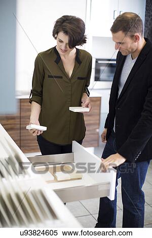 Mid adult couple looking at ceramic tiles in kitchen showroom View Large Photo Image Stock Photography - Mid adult couple looking at ceramic tiles in kitchen showroom. Fotosearch