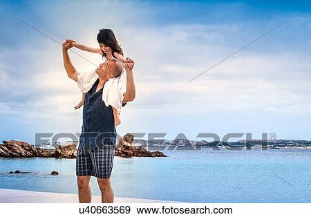 Mid adult man giving daughter shoulder ride on beach, La Maddalena, Sardinia, Italy View Large Photo Image Stock Photo - Mid adult man giving daughter shoulder ride on beach, La Maddalena, Sardinia, Italy. Fotosearch