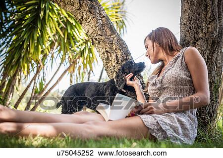 Mid adult woman petting dog in holiday home garden, Capoterra, Sardinia, Italy View Large Photo Image Stock Image - Mid adult woman petting dog in holiday home garden, Capoterra, Sardinia, Italy. Fotosearch