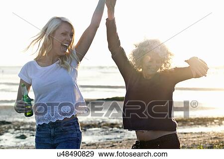 Stock Photo - Mother and daughter dancing on Bournemouth beach, Dorset, UK. Fotosearch