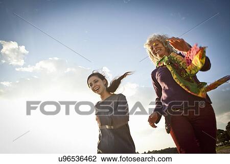 Stock Image - Mother and daughter enjoying beach. Fotosearch