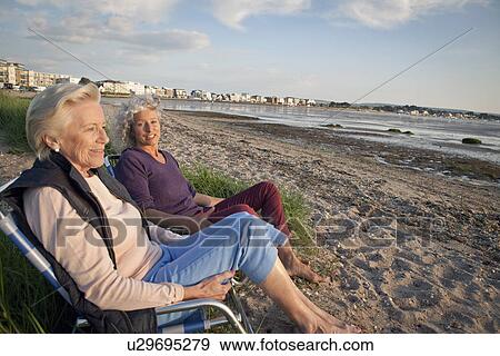 Stock Photo - Mother and daughter enjoying view on beach. Fotosearch
