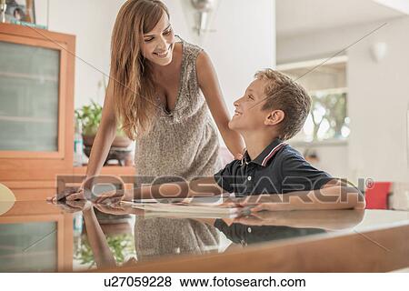 Mother and son doing homework at dining room table View Large Photo Image Stock Photo - Mother and son doing homework at dining room table. Fotosearch