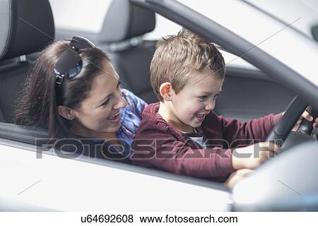 Mother and son trying out new car in car dealership View Large Photo Image Stock Photo - Mother and son trying out new car in car dealership. Fotosearch
