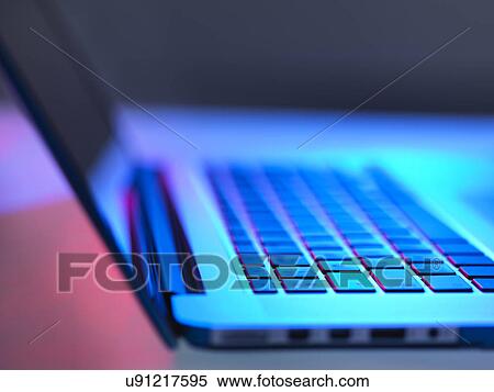 Stock Photography - Open laptop on desk at night. Fotosearch