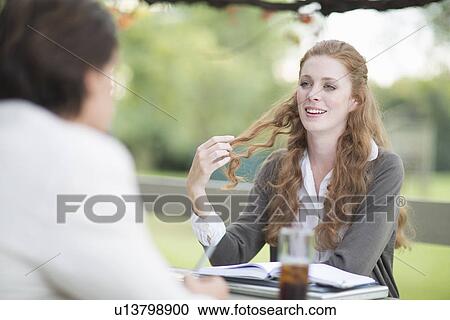 Over the shoulder view of businessman and female colleague having informal meeting in garden View Large Photo Image Stock Image - Over the shoulder view of businessman and female colleague having informal meeting in garden. Fotosearch