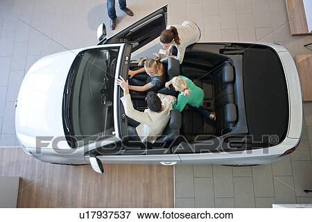 Overhead view of family trying out convertible car in car dealership View Large Photo Image Stock Photo - Overhead view of family trying out convertible car in car dealership. Fotosearch