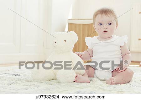 Portrait baby girl and teddy bear sitting on floor View Large Photo Image Picture - Portrait baby girl and teddy bear sitting on floor. Fotosearch