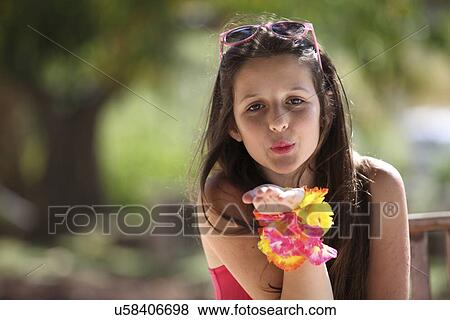 Stock Photo - Portrait of a girl in park blowing a kiss. Fotosearch
