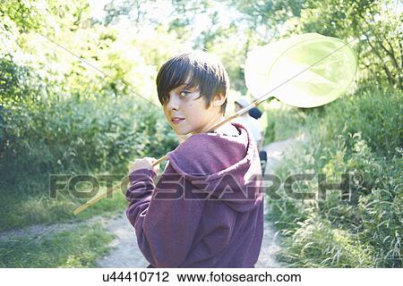 Stock Image - Portrait of boy holding fishing net. Fotosearch