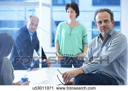 Portrait of businessman, colleagues having discussion in background View Large Photo Image Stock Image - Portrait of businessman, colleagues having discussion in background. Fotosearch