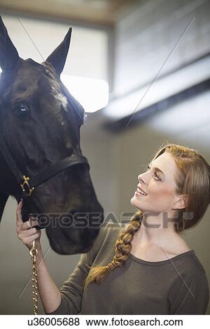 Portrait of female stablehand with horse in stables View Large Photo Image Stock Photo - Portrait of female stablehand with horse in stables. Fotosearch