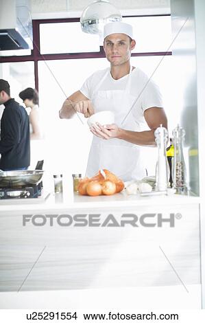Portrait of male chef mixing with mortar and pestle in commercial kitchen View Large Photo Image Picture - Portrait of male chef mixing with mortar and pestle in commercial kitchen. Fotosearch