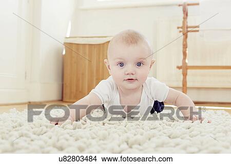 Picture - Portrait of smiling baby boy crawling on rug. Fotosearch